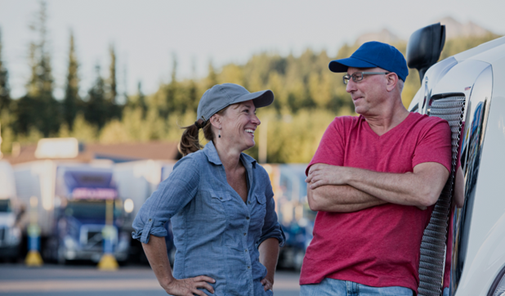Lachende man en vrouw bij vrachtwagen